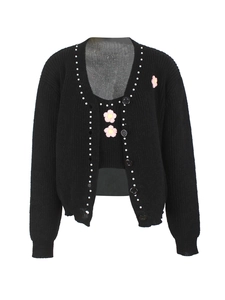 Détail d'un ensemble cardigan en maille côtelée noire avec broderie florale et perles