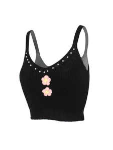 Détail du crop top noir en maille avec encolure en perles et fleurs au crochet roses