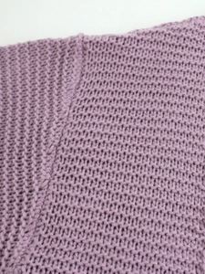 Gros plan du tissu en maille épaisse violet clair avec des détails de couture précis