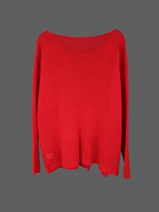 Close-up of bright red knit sweater with long sleeves and wide boat neck design