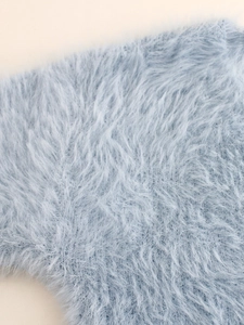Detailed close-up of light blue faux fur fabric with soft plush texture and fluffy fibers