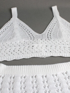Two-piece white knit set featuring a crochet crop top and hollow-out skirt for summer