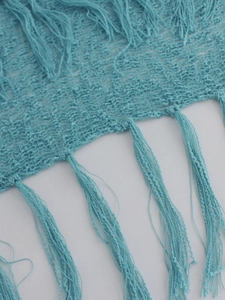 Haut de plage en maille bleu clair à épaules dénudées avec design ajouré et longues franges