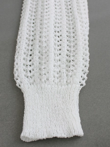 Detailed macro view of white crochet knit cuff featuring hollow out vertical pattern