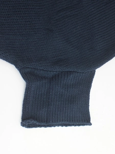 Detailed close-up of dark blue knit sweater cuff showing thick ribbed texture and craft