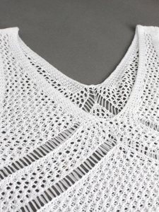Haut blanc en maille crochetée ajourée avec col en V pour un style de vacances à la plage