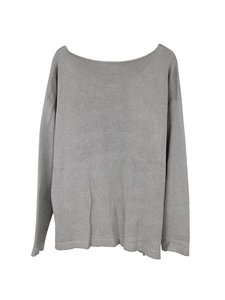 Close-up of gray knit texture on a loose-fit long sleeve boat neck sweater top