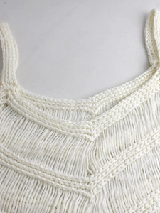 Vue détaillée de la texture du tricot au crochet blanc avec des franges élégantes