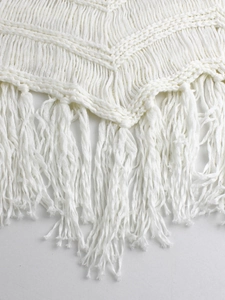 Gros plan sur tissu tricoté ajouré blanc avec détails de franges de style bohème