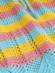 Close-up of colorful striped knit fabric with hollow mesh texture and blue drawstring detail