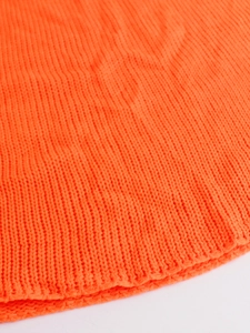 Close-up detail of bright orange ribbed knit texture showing the fine elastic stitch patterns