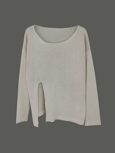 Detail of off-white knit sweater showing the stylish front side slit and fine texture