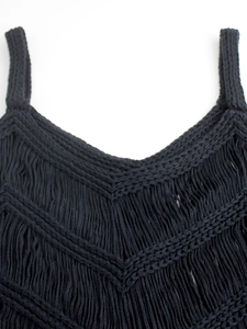 Détail de ce haut noir en maille bohème avec finitions à franges en forme de V élégantes