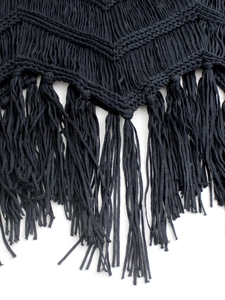 Détail du haut de plage en crochet noir avec texture en V et longues franges de bohème