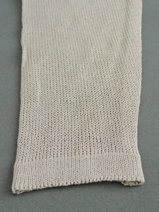 Macro detail of cream-colored ribbed knit texture on long sleeve sweater cuff