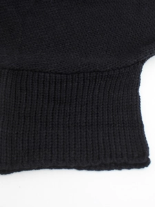 Close-up detail of the ribbed cuff texture on a loose black knit sweater for women