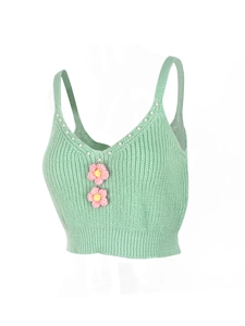 Détail d'un caraco en tricot vert clair avec fleurs au crochet et perles blanches