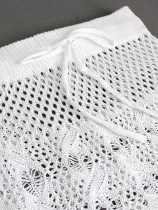 Detailed close-up of white crochet knit waist with adjustable drawstring and hollow pattern
