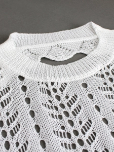 White knit crewneck top featuring intricate hollow patterns for beach vacation style