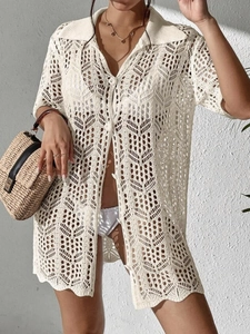 Détails de la maille crochetée ajourée et des boutons sur un cardigan de plage beige