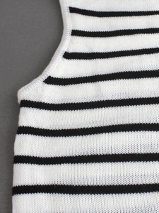 Gros plan d'un débardeur en maille rayée avec des bords côtelés et un tissu en coton
