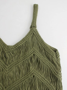 Gros plan détaillé d'un haut au crochet vert olive avec des franges et un motif en V