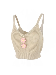 Détail d'un crop top en maille côtelée avec perles et petites fleurs crochetées
