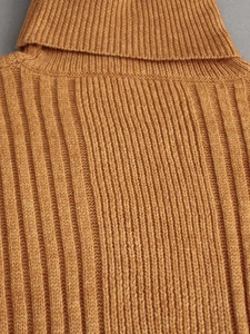 Detailed macro view of the ribbed knit texture and high turtleneck seam in mustard yellow