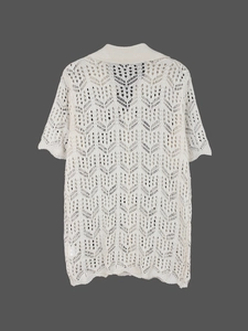 Détail du cardigan en maille beige avec motifs de feuilles ajourés et col à revers côtelé