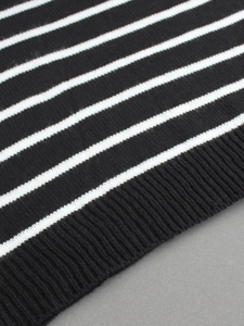 Gros plan sur un tricot rayé noir et blanc avec texture détaillée de l'ourlet côtelé