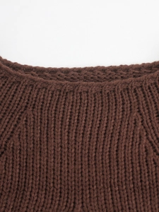 Detail of round neckline and raglan sleeves on dark brown chunky knit sweater