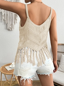 Détail du dos d'un haut au crochet beige avec motifs de vagues et de longues franges