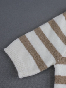 Détail du poignet côtelé et texture en maille rayée douce du pull à manches courtes