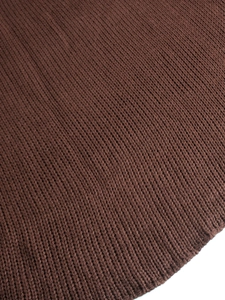 Detailed close-up of brown chunky knit fabric showing high-quality woven texture