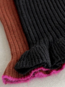 Knitted leg warmers in black, brown, and pink with plush faux mohair trim and ribbed texture
