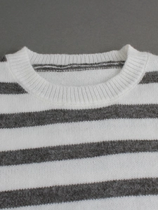 Gros plan du col rond côtelé et de la texture en maille douce du pull rayé gris