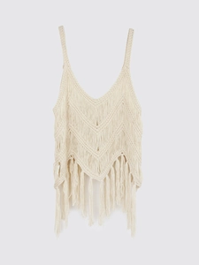 Détail d'un caraco bohème en tricot crème avec motif en V et ourlet à franges