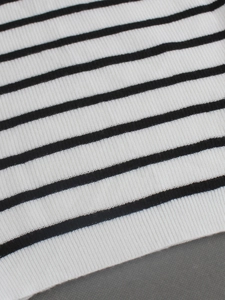 Gros plan sur la texture en maille côtelée et le motif à rayures noires et blanches