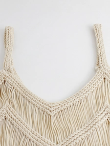 Détail du haut en tricot bohème montrant le col en V et les longues franges