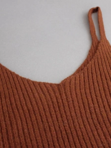 Detailed close-up of V-neck knitted camisole top featuring vertical ribbed texture
