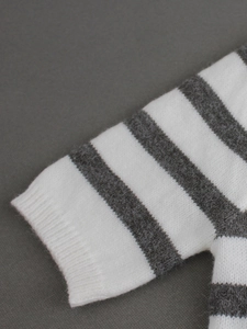 Gros plan sur un pull en maille rayée avec texture pelucheuse et poignets côtelés