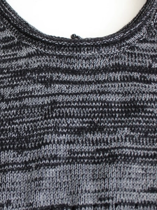 Gros plan détaillé sur l'encolure en V en tricot chiné noir et gris avec coutures nettes
