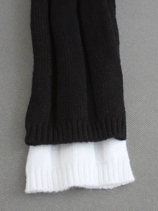 Close-up of black and white knit texture with ribbed stitch detail on long sleeve set