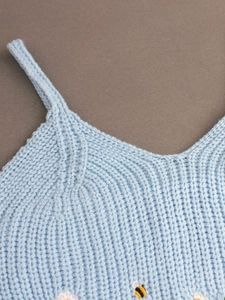 Detail of light blue rib-knit camisole with small bee and white flower embroidery
