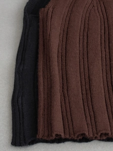 Close-up of slim fit knitted tank top fabric showing black and brown ribbed texture details