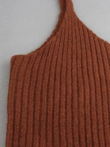 Detail of ribbed knit fabric texture on a rust brown camisole showing vertical patterns