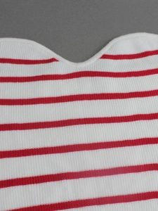 Gros plan sur la texture du tricot à rayures rouges et blanches et l'encolure