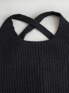 Women's black ribbed knit two-piece set featuring crossover straps and cropped vest design