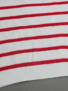 Gros plan d'un tissu en maille côtelée à rayures rouges et blanches détaillées