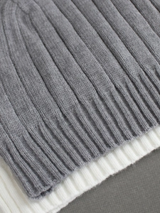 Close-up of V-neck ribbed knit two-piece set in grey and beige soft fabric